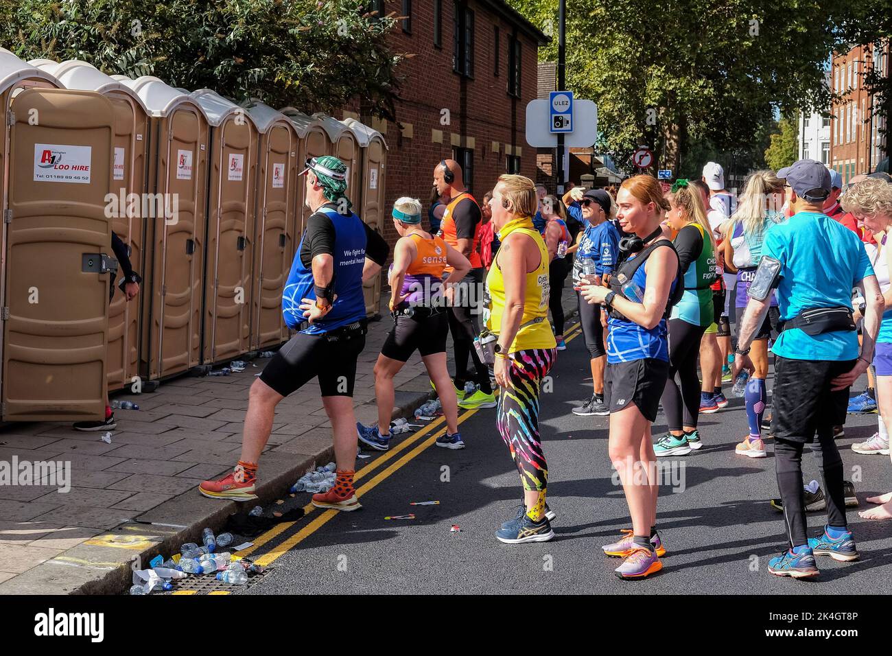 London, 2.. Oktober 2022. Mehr als 40.000 Teilnehmer gehen zum London Marathon 42. auf die Straßen der Hauptstadt. Die Veranstaltung, die Eliteläufer und Rollstuhlfahrer anzieht, bringt auch Millionen Pfund für wohltätige Zwecke durch die Teilnahme von Club- und Fitnessläufern zusammen mit denen, die nur die 26 Meilen Herausforderung annehmen wollen. Die Teilnehmer müssen sich anstellen, um während des London-Marathons tragbare Toiletten zu benutzen. Stockfoto