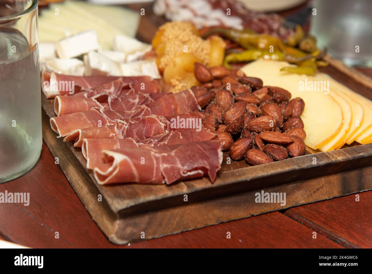 Partygäste können das Charcuterie-Brett mit Aufschnitt, gerolltem Roastbeef und anderen Proteinen essen. Stockfoto