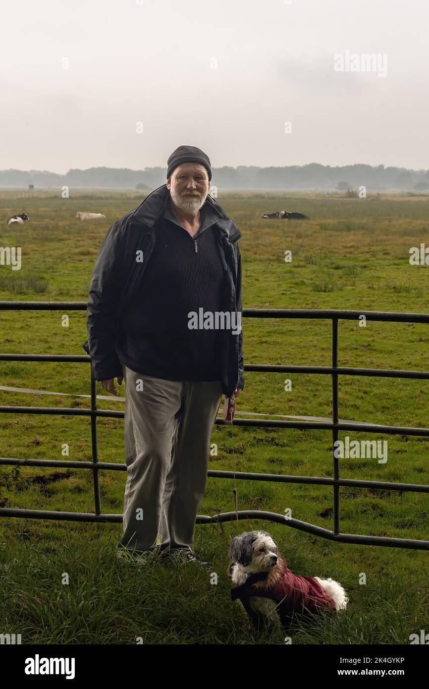 Mann mit seinem Hund vor einem Vieh Stockfoto