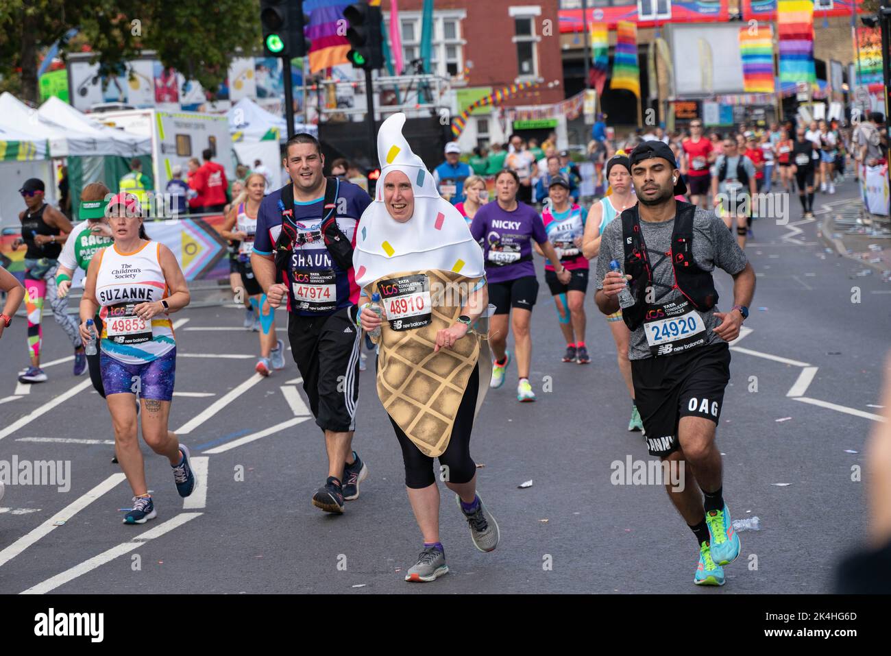 London, Großbritannien. 02. Oktober 2022. Marathonläufer in der Rainbow Row. Zum ersten Mal wurde eine Strecke der London Marathon-Route in Rainbow Row umgewandelt, um die LGBTQIA-Community zu feiern, die Inklusivität zu fördern und eine Partyatmosphäre zu schaffen, die auf der Meile 21 aufgeht. Marathonläufer passieren zwei Etappen mit Musik- und Drag-Darbietungen und die Straße, die in der Regel Butcher Row in Limehouse heißt, ist mit bunten Flaggen und Adern bedeckt. Kredit: SOPA Images Limited/Alamy Live Nachrichten Stockfoto