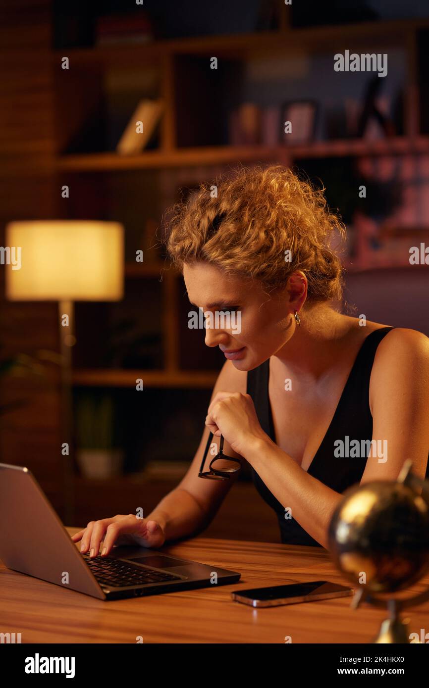 Zielgerichtete junge Geschäftsfrau, professionelle Unternehmerin, arbeitet hinter einem Laptop. Geschäftsfrau, in einem schönen Büro im Kinolicht. Finanzen Stockfoto