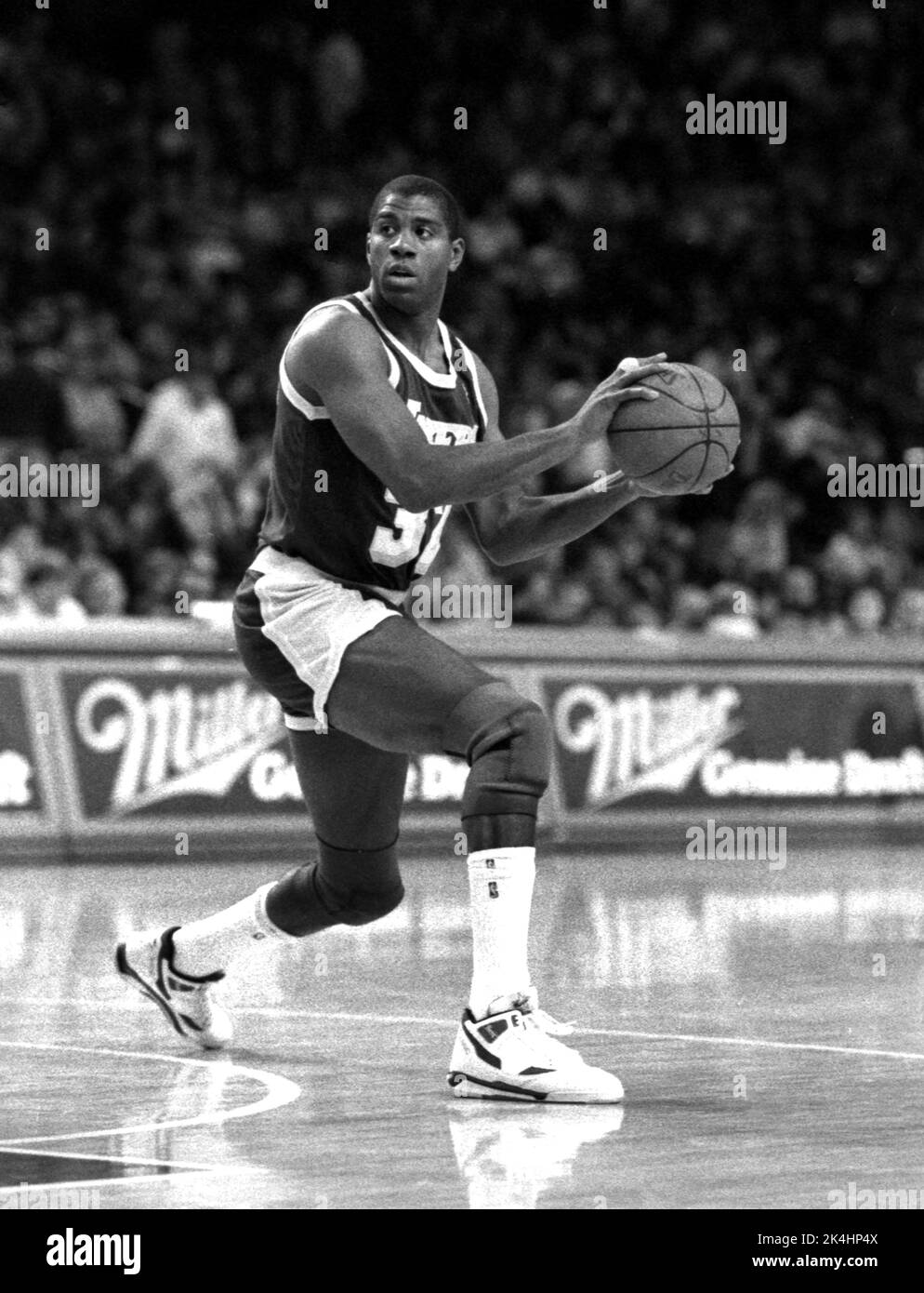 NBA-Superstar Ervin 'Magic' Johnson von den Los Angeles Lakers bringt den Ball während eines Spiels gegen die Chicago Bulls in den 1980s. Stockfoto