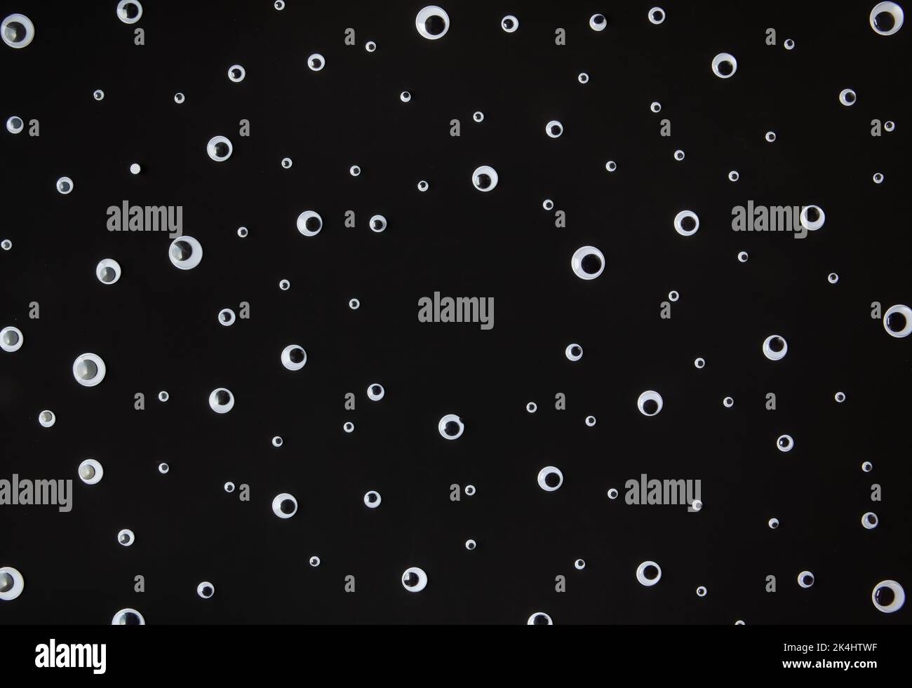 Googly Augen Kunststoff-Spielzeug auf schwarzem Hintergrund Stockfoto