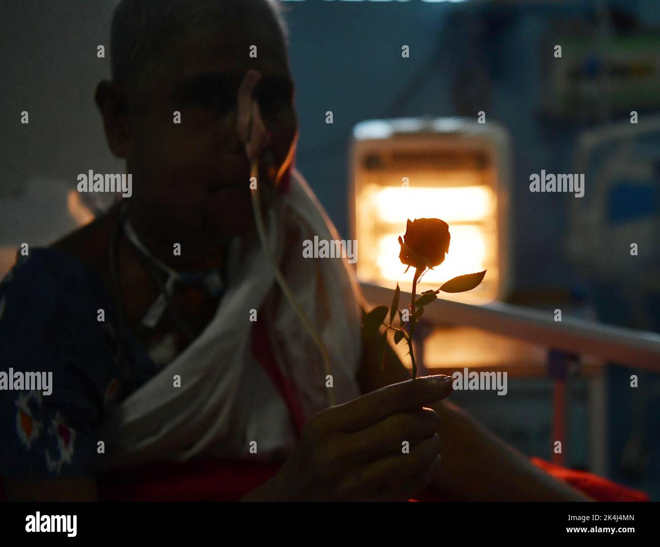 Ein Krebspatient hält eine Rose bereit, die von Ärzten und Krankenschwestern am Welt-Rosentag für das Wohlergehen von Krebspatienten verteilt wird, der jedes Jahr am 22.. September beobachtet wird, um Menschen für Krebs zu sensibilisieren und Patienten eine helfende Hand zu reichen. Atal Bihari Vajpayee Regional Cancer Center in Agartala. Tripura, Indien. Stockfoto