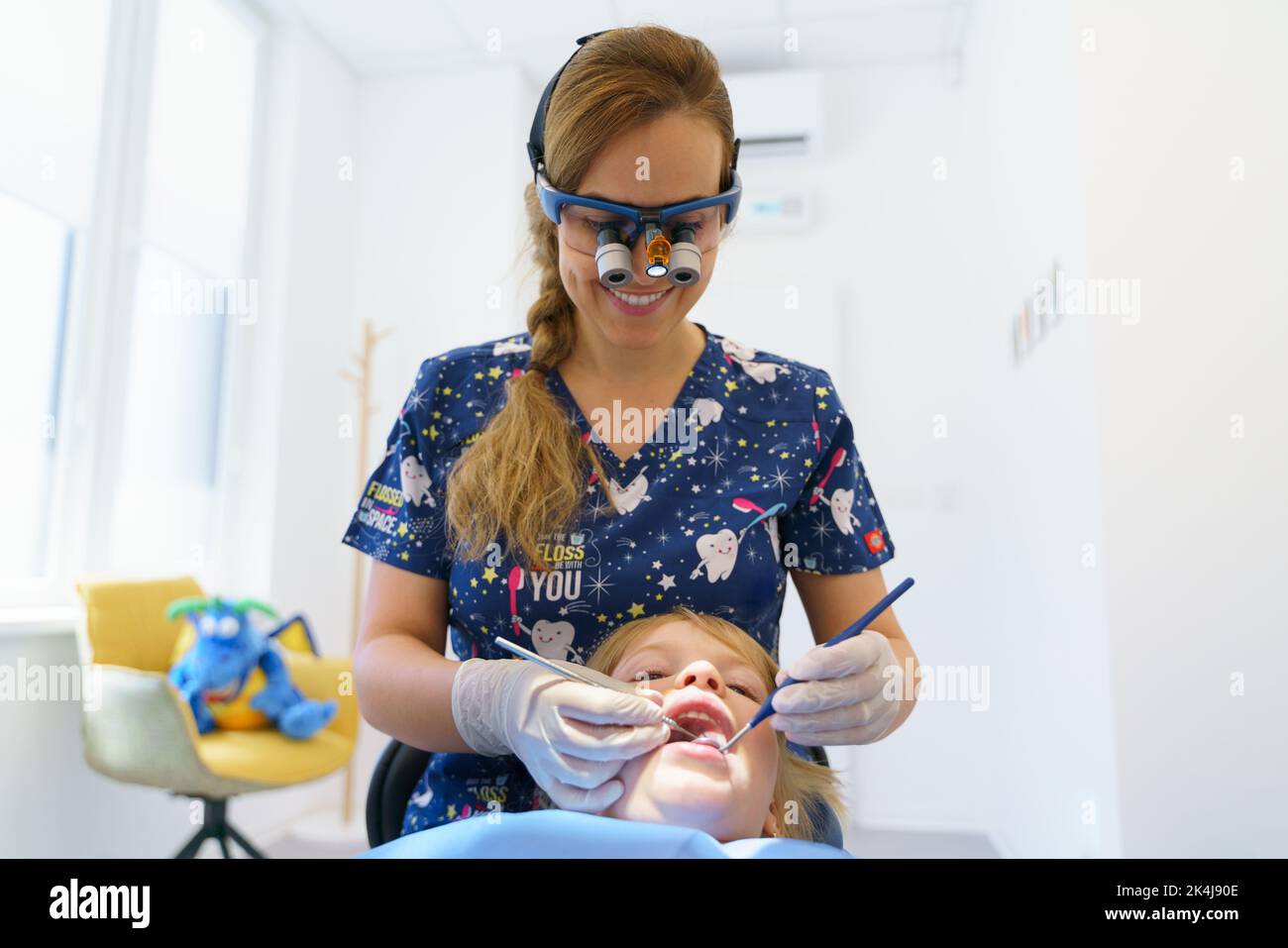 Junge Frau Zahnarzt tun präventive Untersuchung kleine Mädchen. Stockfoto