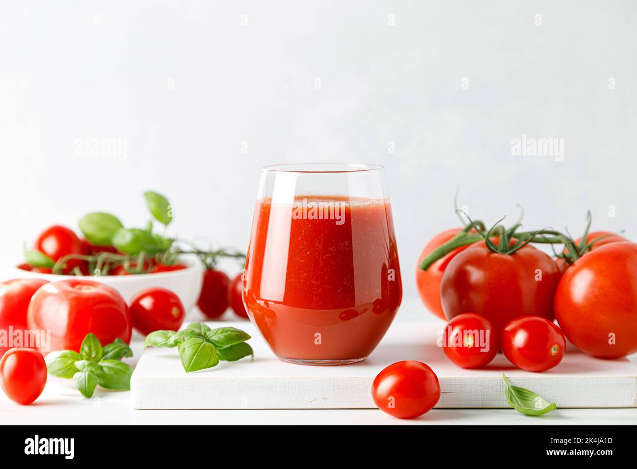 Tomatensaft im Glas und frische Tomaten Stockfoto