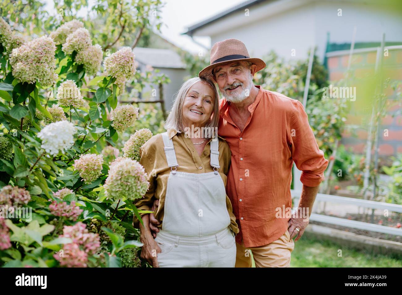 Verliebte ältere Paare posieren gemeinsam in ihrem Garten. Stockfoto