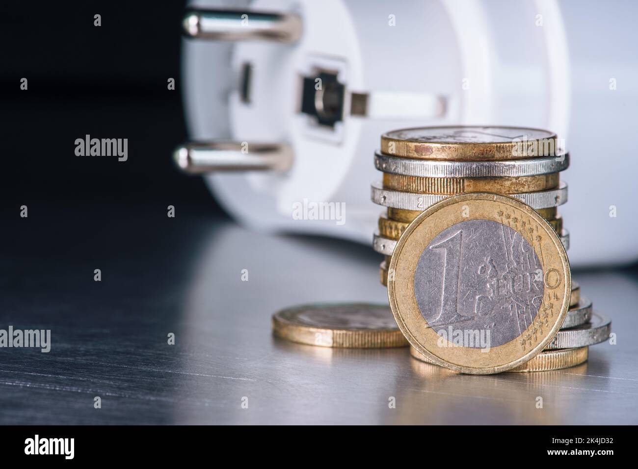 Euro-Münzen und Elektrostecker, Inflationskonzept und steigende Energiepreise Stockfoto