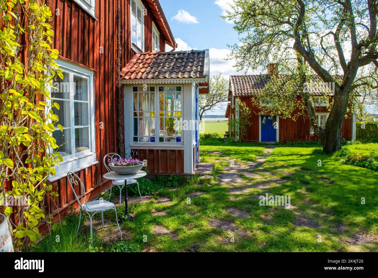 Ein falurotes Wohnhaus mit Veranda und Garten vor dem Haus, Sörmland, Schweden Stockfoto
