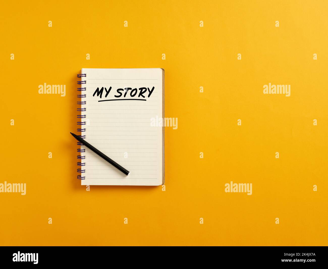 Notizblock und schwarzer Stift auf gelbem Hintergrund mit dem handgeschriebenen Wort meine Geschichte. Erzählen über sich selbst und Biographie Konzept. Stockfoto