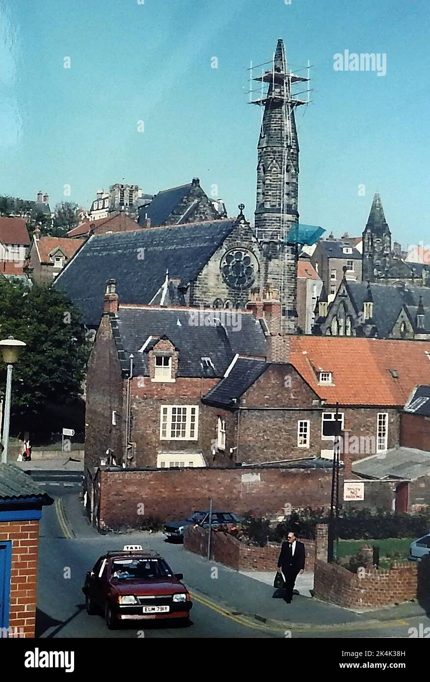 1987STEEPLEJACKS - Blick vom Spring Hill und Princess Place der Arbeiter, die einen instabilen alten Turm durch einen kürzeren Glasfaserersatz auf die katholische Kirche am Fuße der Brunswick Street in Whitby North Yorkshire ersetzten. . Das Grundstück rechts vom Mann rechts war einst der Ort der alten Polizeiwache der Stadt. Stockfoto