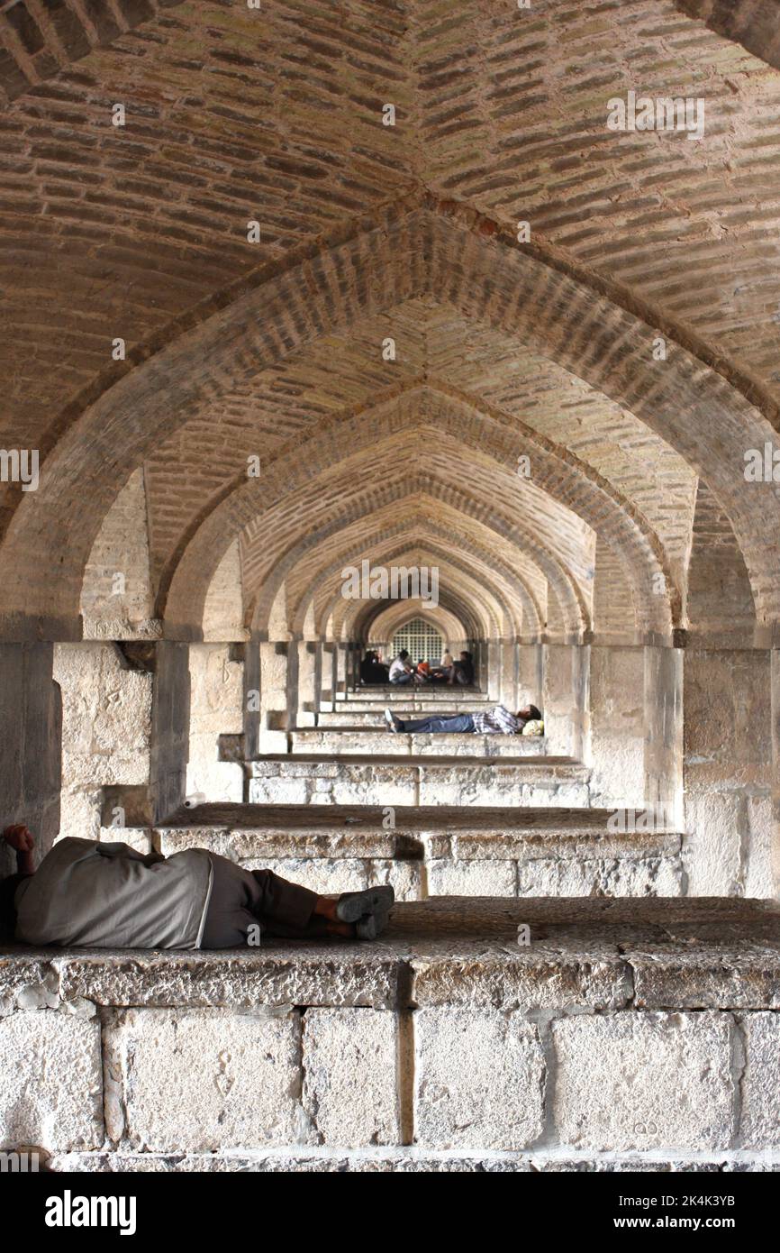 Schlafen unter den Bögen der Si-oh-eh-Brücke, Isfahan, Islamische Republik Iran Stockfoto