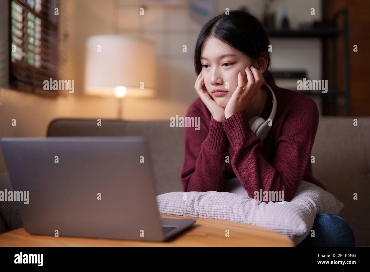 Attraktive junge Frau Videoanruf per Laptop auf Sofa zu Hause. Lifestyle-Konzept Stockfoto