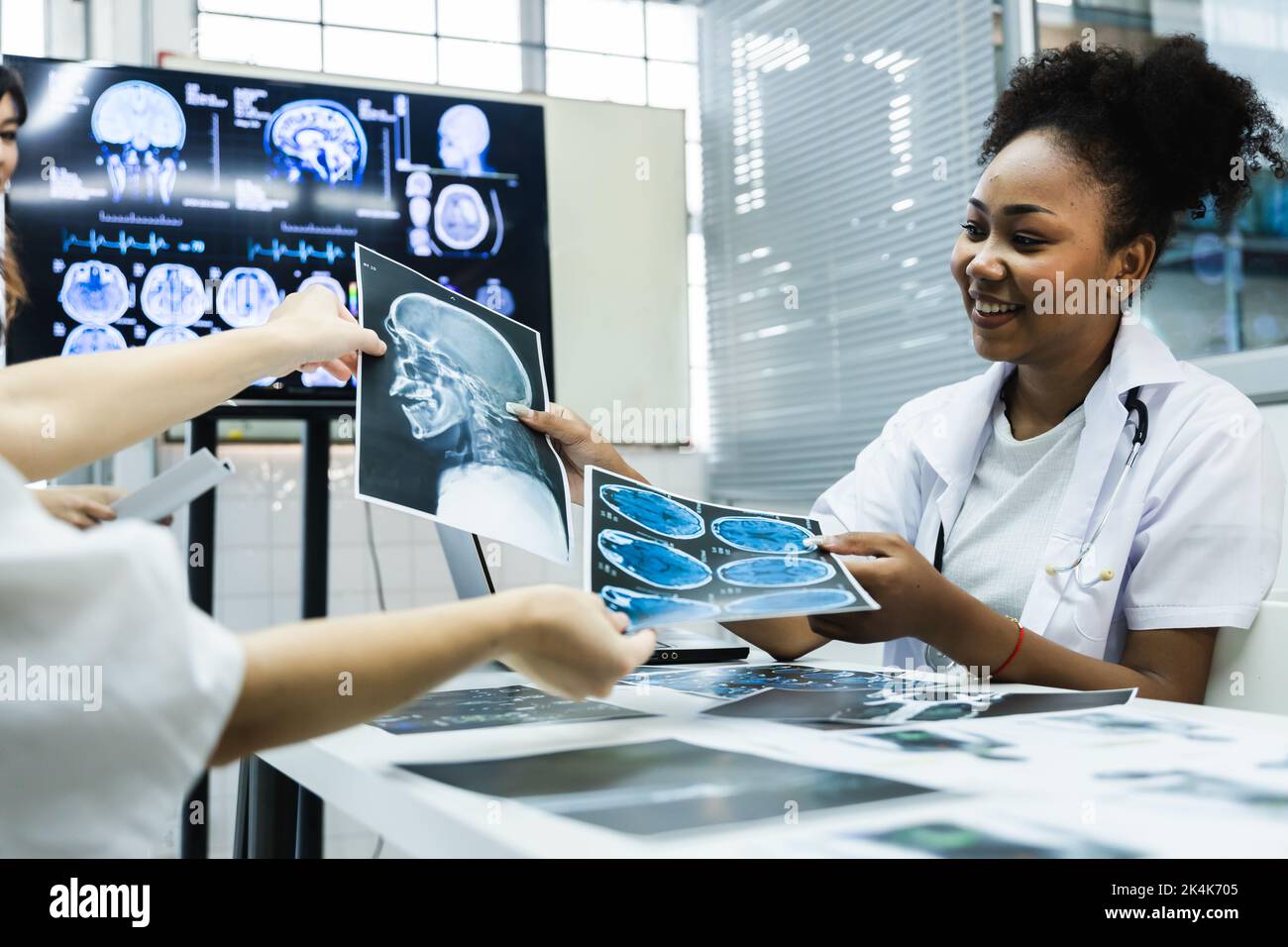 Das Ärzteteam überprüft die Ergebnisse des Scans und schaut sich Monitore im Labor an, teilt medizinisches Wissen und Erfahrungen, von denen ihre Mitarbeiter profitieren Stockfoto