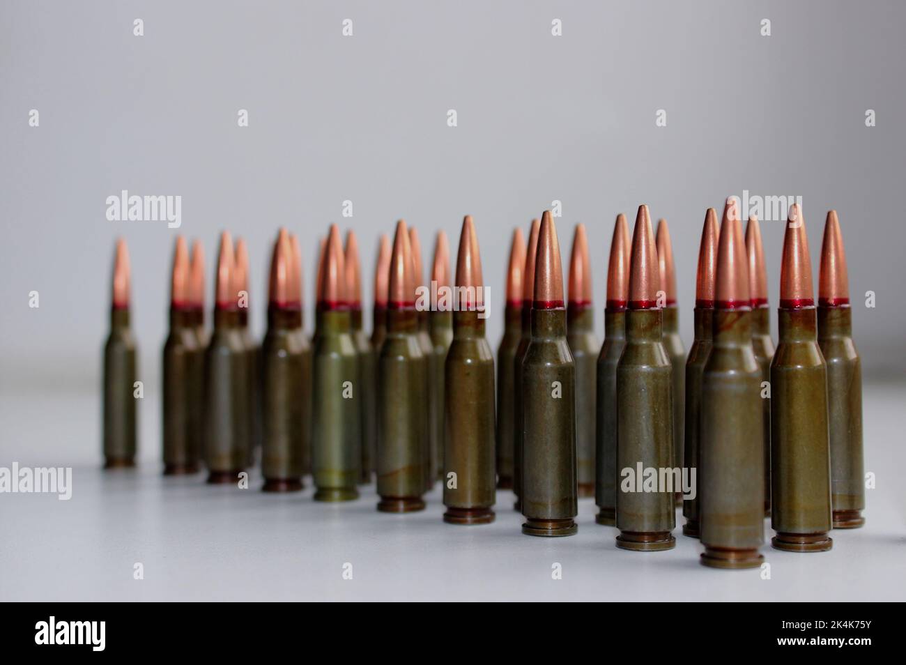Volljacke Kugeln für Sturmgewehr in einer Reihe defokussiert auf dem Rand Stock Foto Stockfoto