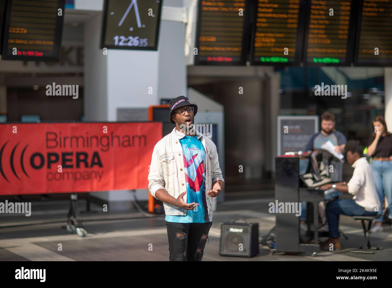 Ein Mitglied der Birmingham Opera Company tritt im Birmingham New Street Station Grand Central auf Stockfoto