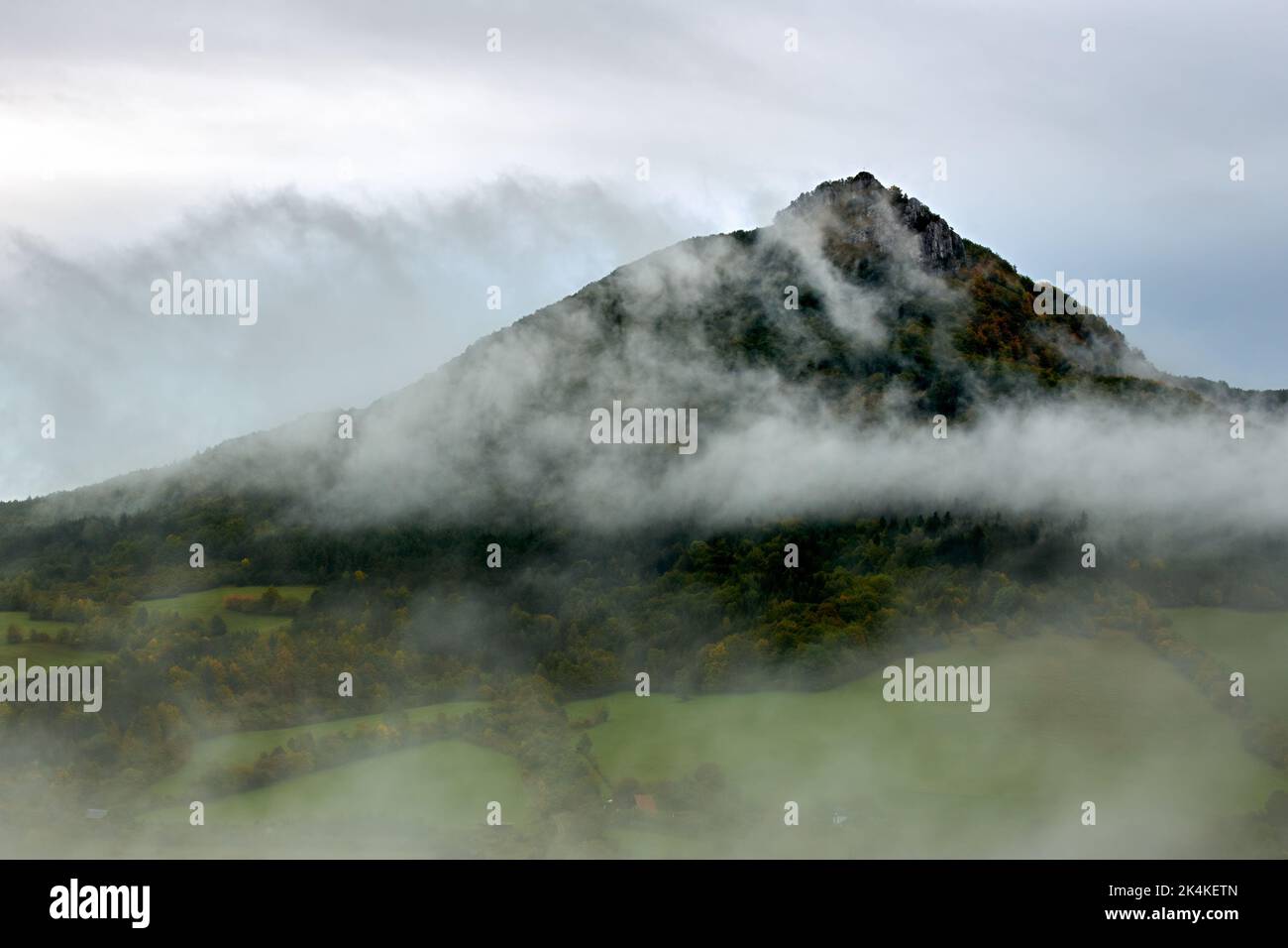 Herbstmorgen neblige Landschaft mit rollendem Nebel ins Tal. Hill Vapec im Hintergrund. Natur Europas. Slowakei. Stockfoto