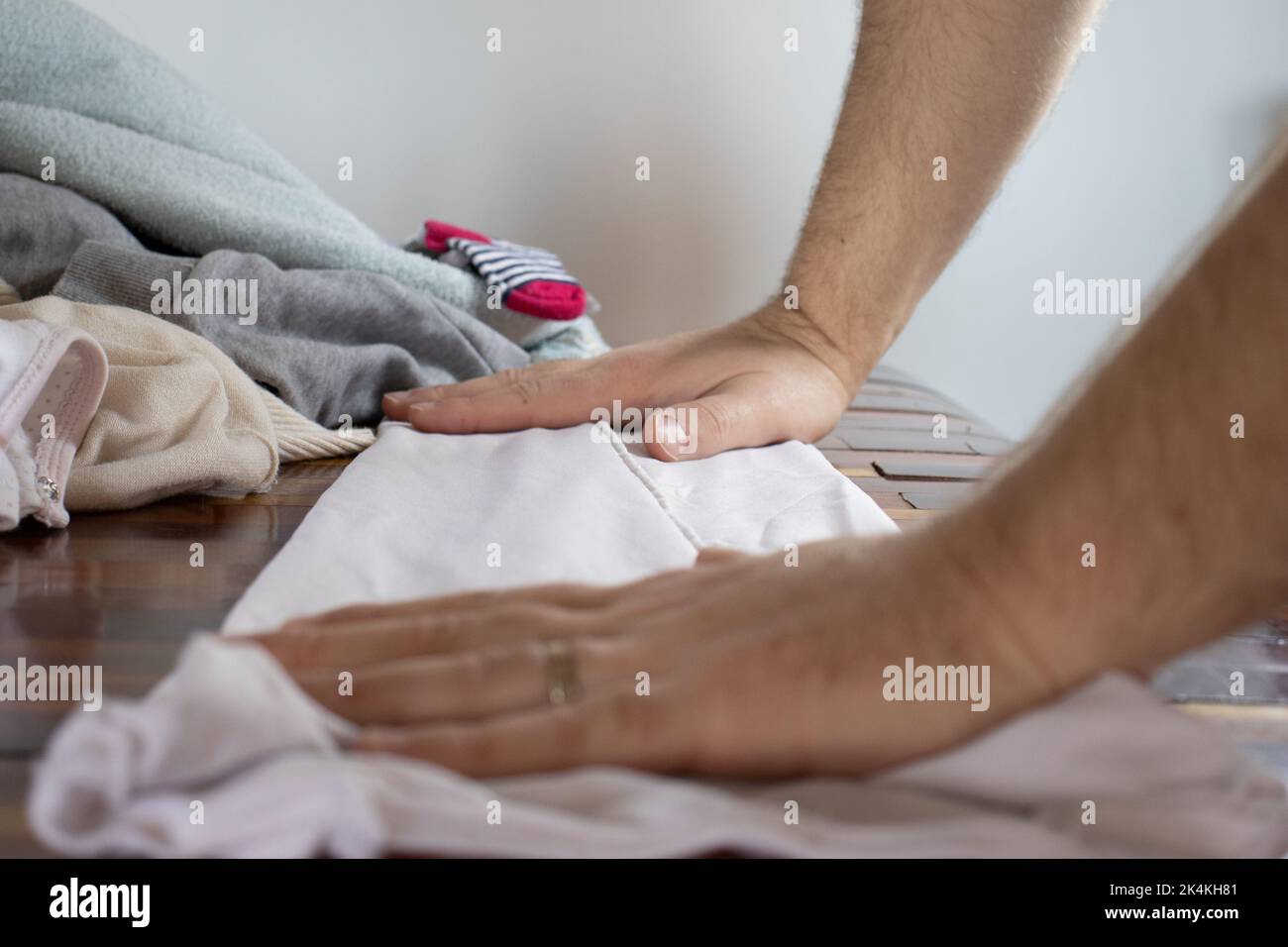 Verheirateter Mann, der frisch gewaschene Kleidung arrangierte Stockfoto