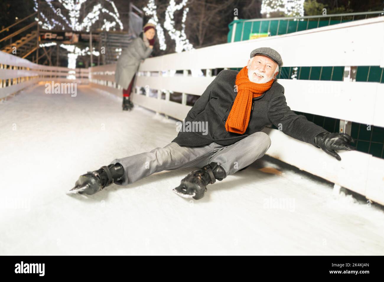Ein älterer Mann, der Eislaufen genießt und Schal und Jacke trägt, fühlt sich koofig an Stockfoto