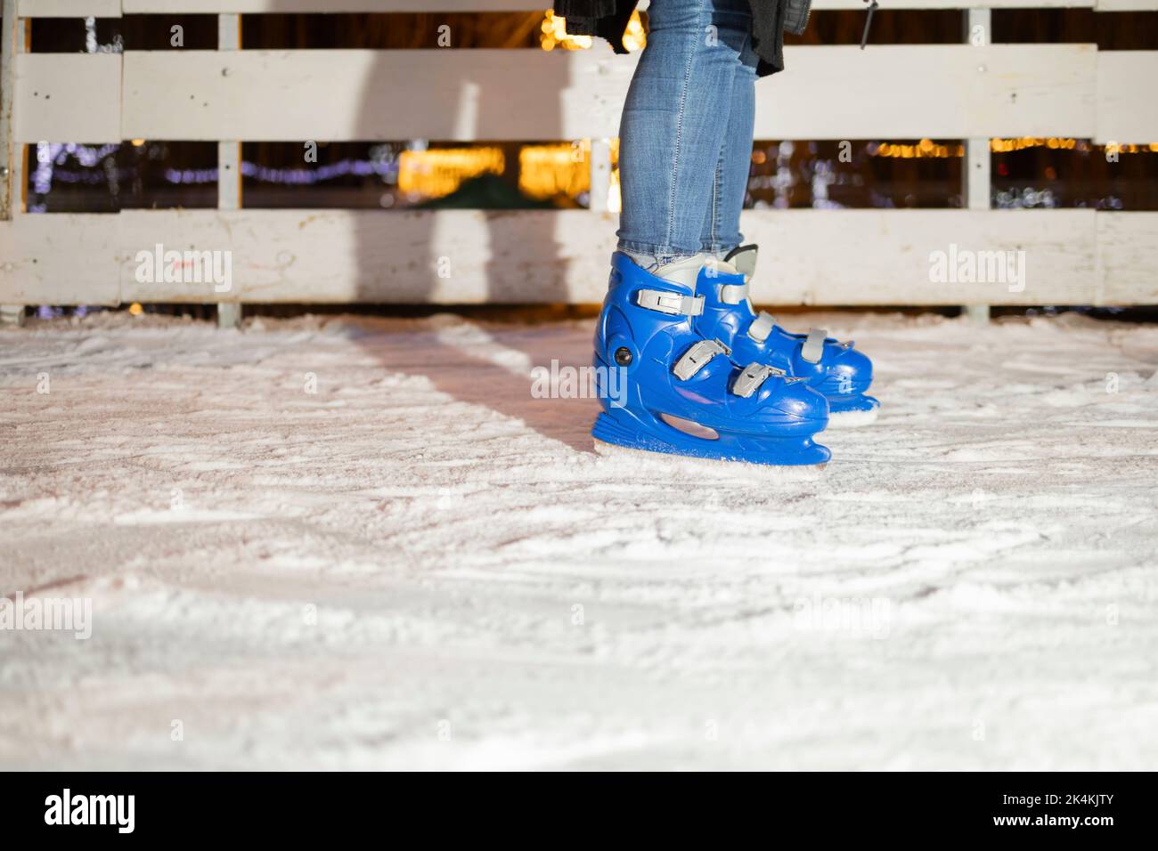 Beine in blauen Schlittschuhe und Winterkleidung Stockfoto