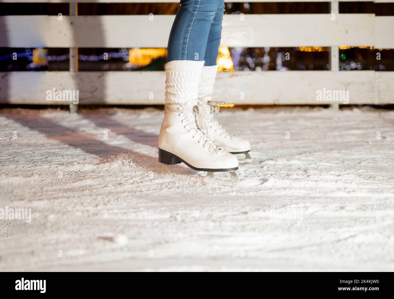 Weibliche Beine in weißen Schlittschuhe Stockfoto