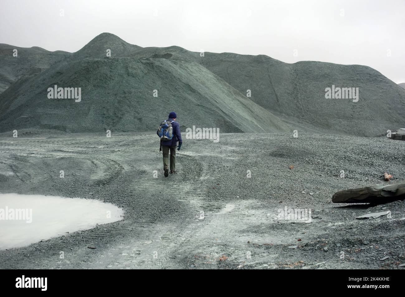 Der einträchtige Mann, der am Honister Slate Quarry vorbei an Verderbhaufen vorbeigeht, führt zu den Wainwright „Grey Knotts“ im Lake District National Park, Cumbria, England. Stockfoto