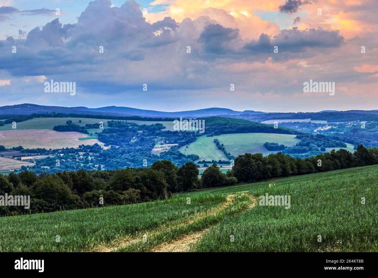 Sommer ländliche Landschaft mit Pfad im Feld.. Schöner Himmel mit bunten Wolken. Blick von oben ins Tal. Horna Suca, Slowakei. Europa Stockfoto