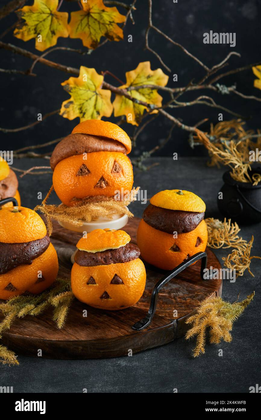 Halloween Party Jack-o-Laterne Schokolade orange Kuchen vor dem Hintergrund des alten Waldes, Äste und Blätter. Halloween-Food-Konzept. Süßigkeiten Stockfoto