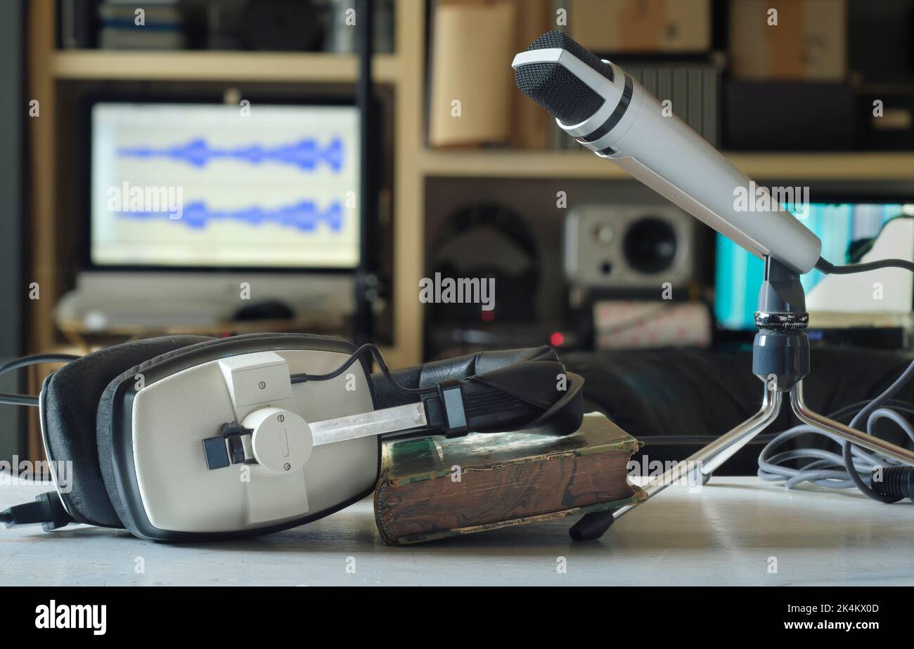 Podcasting-Konzept, Vintage-Kopfhörer und Aufnahmemonton auf unordentlicher Arbeitsfläche, selektiver Fokus Stockfoto