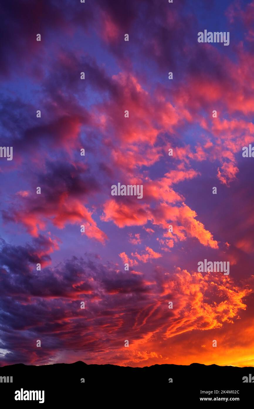 Erstaunlicher farbenprächtiger Sonnenuntergang- oder Sonnenaufgangshimmel mit orangefarbenem Pink-Lila und blauem Dramatik Stockfoto