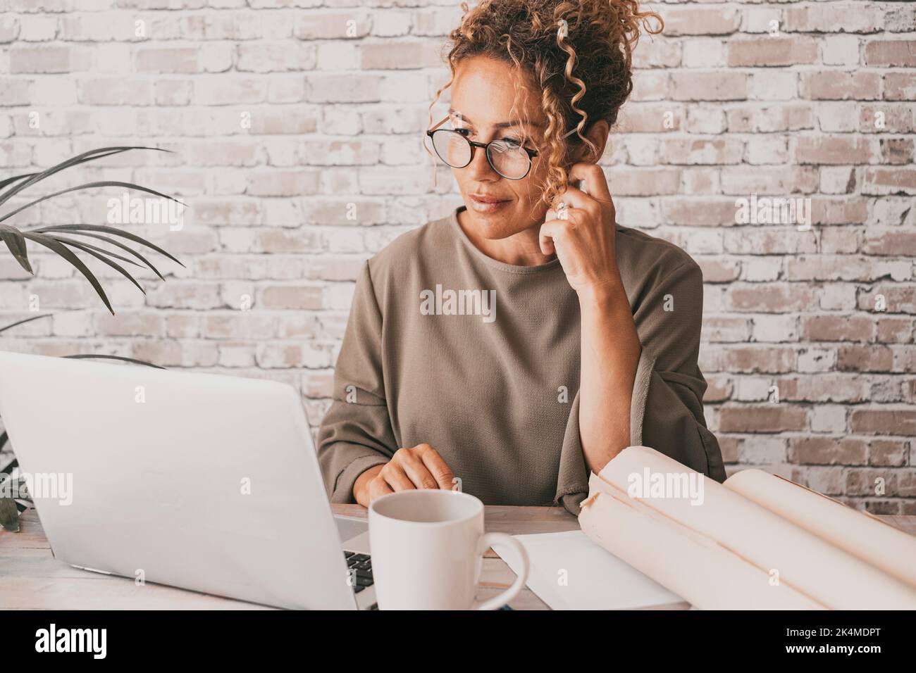 Professionelle Unternehmer arbeiten allein am Schreibtisch des Heimbüros mit Laptop und Papierdokumenten. Business online Job weibliche Menschen suchen Laptop Stockfoto