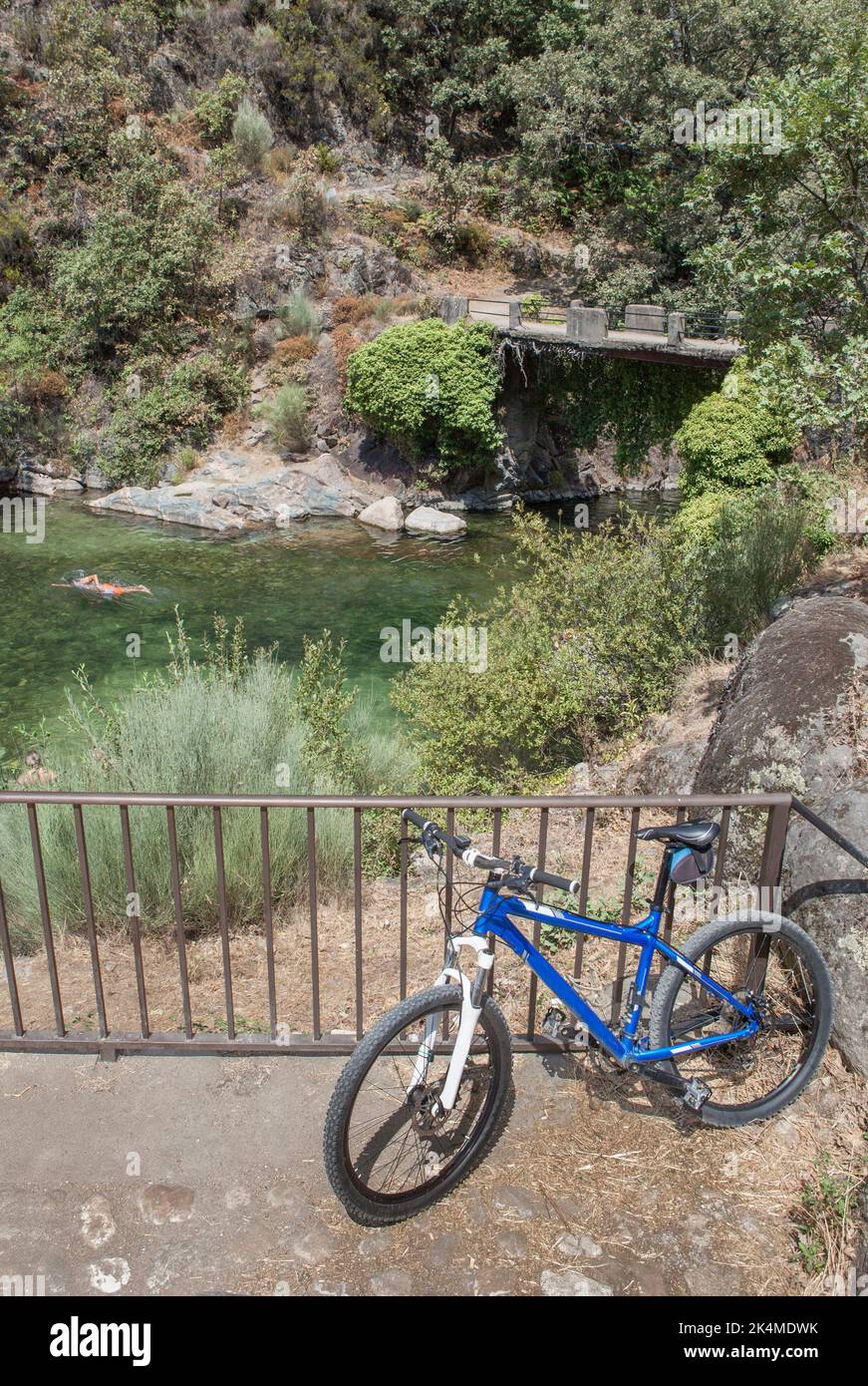 MTB-Fahrrad neben dem natürlichen Schwimmbad La Maquina, Guijo de Santa Barbara, Spanien. Toller Ort für Triathlon-Praktizierende. Stockfoto