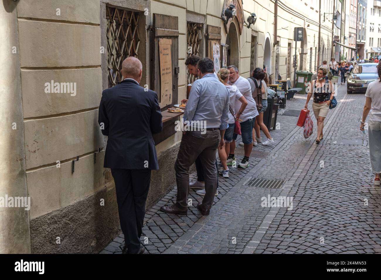 Menschen, die draußen auf der Straße zum Mittagessen in der Stadt Bozen Italien stehen. Stockfoto