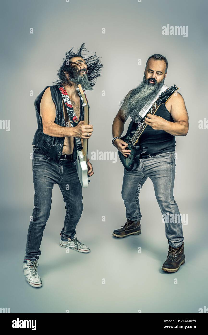 Rocker mit langem Bart spielen Bass und Gitarre, Studioaufnahme Stockfoto