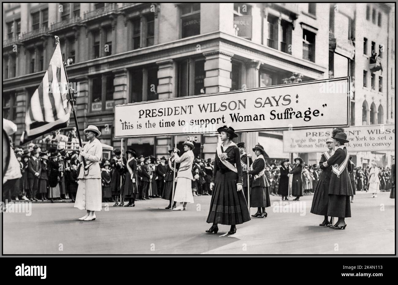 frauenwahlrecht demonstration märz 19. Amendment USA Banner mit Schlagzeile 'PRÄSIDENT WILSON SAGT... „Dies ist die Zeit, das Frauenwahlrecht zu unterstützen“ Amerika USA 1915 Stockfoto