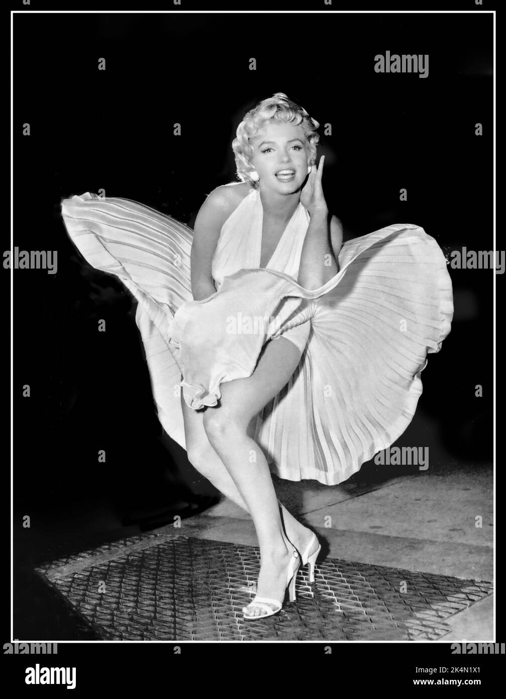 Der Rock von Marilyn Monroe wird in die Luft gesprengen, um das 7 Year Itch Vintage Film Retro-Bild 1950s zu bewerben, während der Film „The Seven Year Itch“ auf den Straßen von New York gedreht wurde, Sie blieb offenbar während der Dreharbeiten zur berühmten „Rock-Szene“ stehen und posierte für die Reporter und Fotografen, die den Film filmten. Das Ergebnis ist ein ikonisches Bild, das den Film sofort hervorgebracht hat. Datum: 9. September 1954 Stockfoto