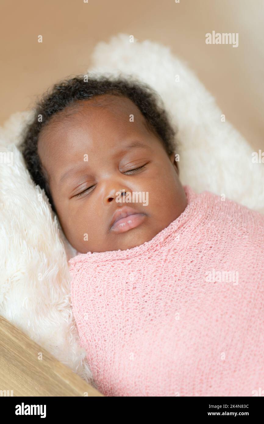 Schwarzes afrikanisches Baby Mädchen, das ein Nickerchen macht, wickelte sich das Studio aus nächster Nähe ein Stockfoto