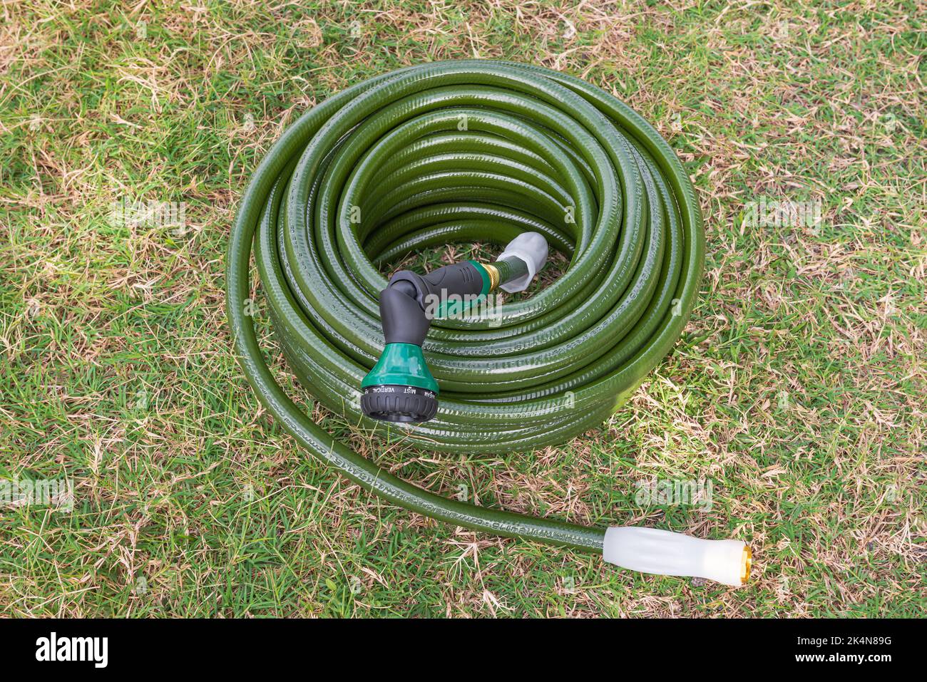 Gartenschlauch grünen Rasen neue Gartengeräte eingewickelt bis gewickelt Stockfoto