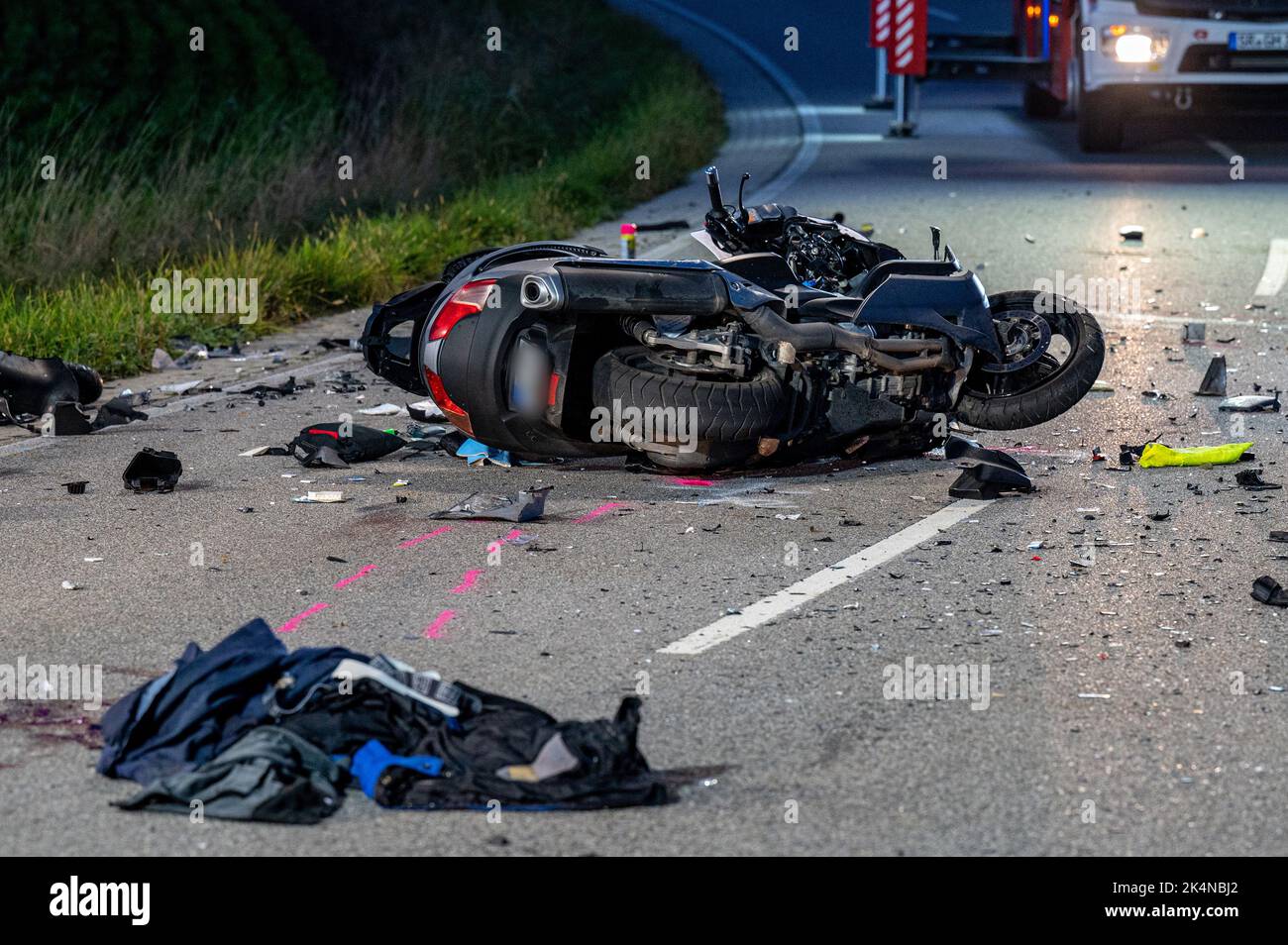 03. Oktober 2022, Bayern, Geiselhöring: Ein völlig zerstörtes Motorrad liegt auf einer Straße. Bei einem Unfall zwischen einem Auto und einer Gruppe von Motorradfahrern starb einer der Motorradfahrer. Ein zweiter Motorradfahrer wurde schwer verletzt ins Krankenhaus gebracht. Foto: Armin Weigel/dpa - ACHTUNG: Kennzeichen(e) wurden aus rechtlichen Gründen verpixelt Stockfoto