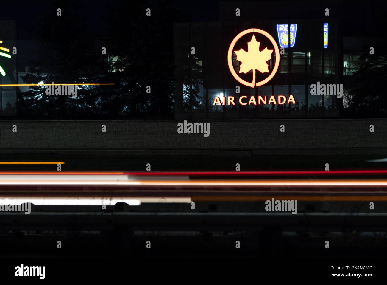 Das Air Canada Logo ist auf einem Schild beleuchtet, das nachts auf einer geschäftigen Autobahn zu sehen ist. Air Canada ist Kanadas nationale Fluggesellschaft und größte Fluggesellschaft. Stockfoto