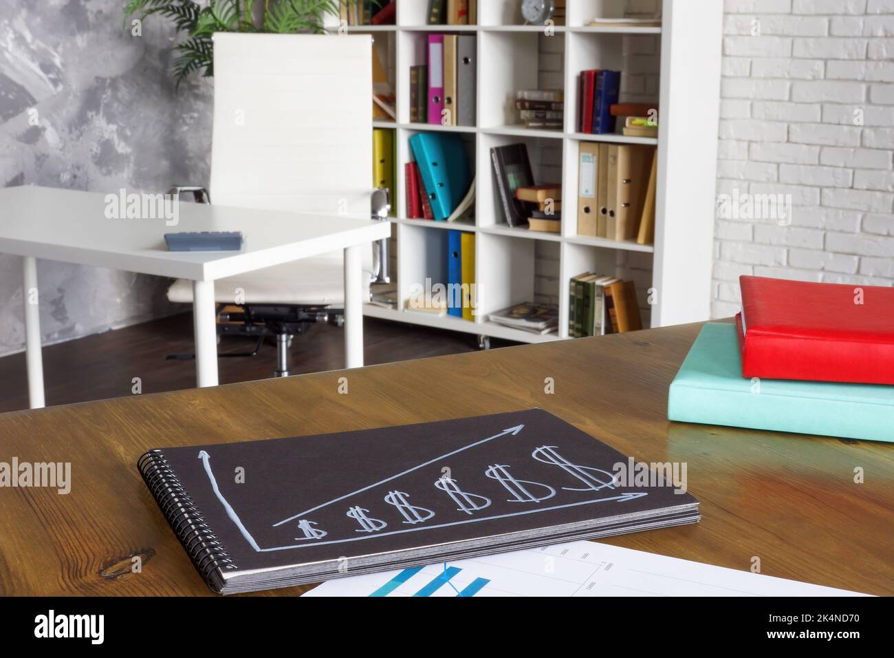 Diagramm des Einkommenswachstums und der Einsparungen auf dem Tisch im Büro. Stockfoto