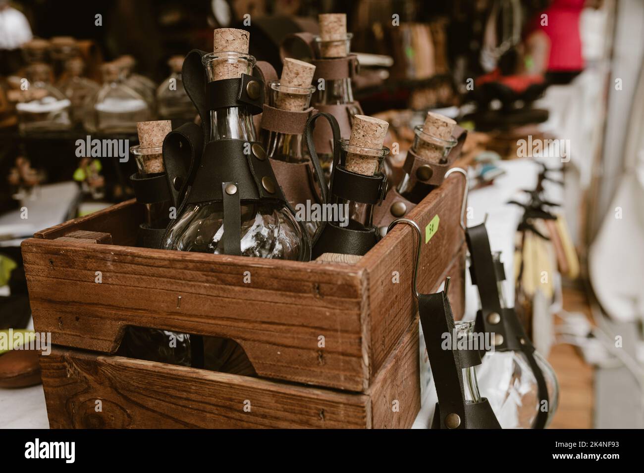 Holzkiste mit Trank-Flaschen mit (Lederhaltern) auf einem Marktstand, Flaschen für Cosplay-Kostüme. Stockfoto