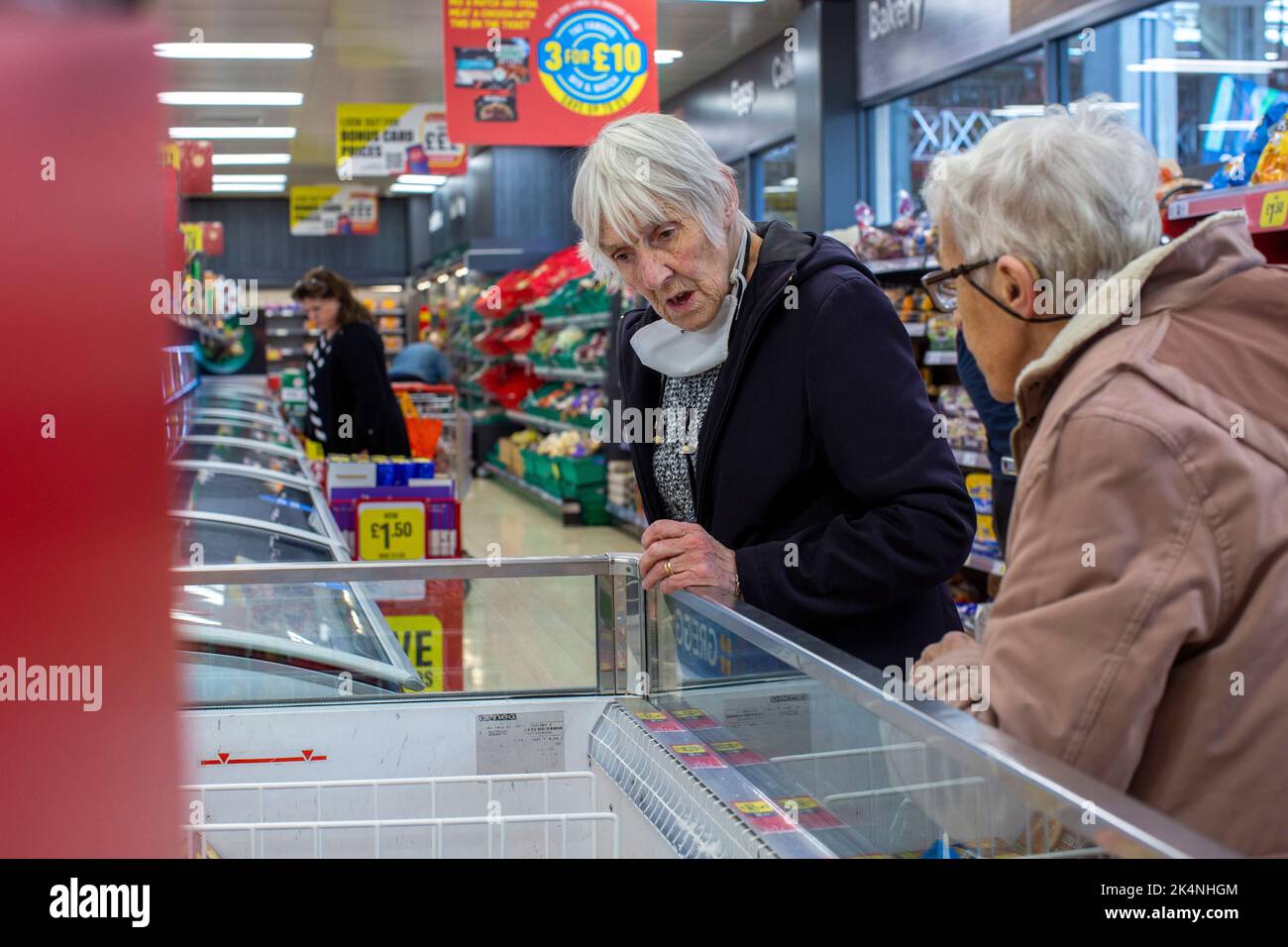 London, Großbritannien. Sept 29 2022 .eldery Frau Shopper Check out der Preis für Ofen fertige Mahlzeit in Kühlschrank in Island Store in Lewisham, London Stockfoto