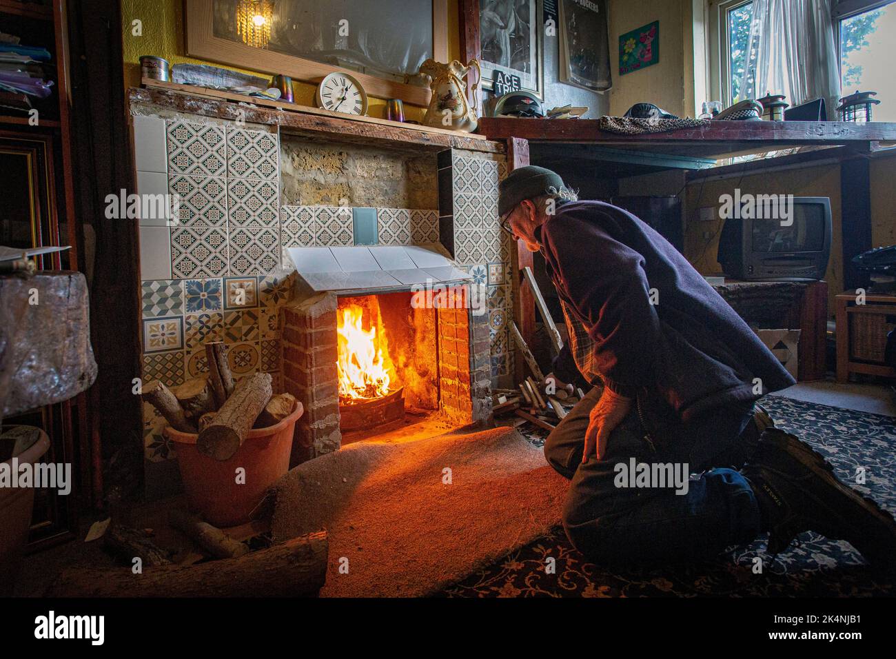 London, Großbritannien. September 29 2022 .man öffnete seinen gemauerten Kamin im Wohnzimmer, damit er Holz verbrennen konnte, um in diesem Winter warm zu bleiben. Stockfoto