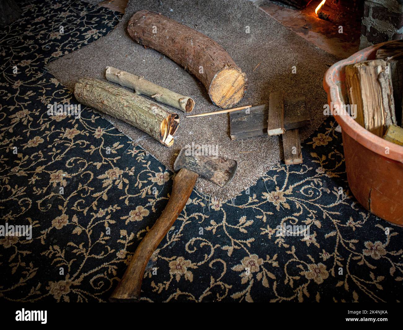 AX mit gehacktem Holz für Feuer im Wohnzimmer. Stockfoto