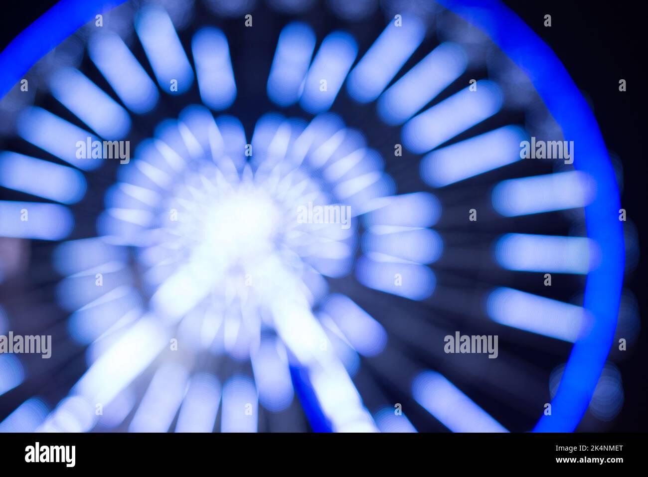 Verschwommenes Foto vom Riesenrad im Stadtzentrum. Winter saisonal Nacht Stadt Hintergrund. Stockfoto