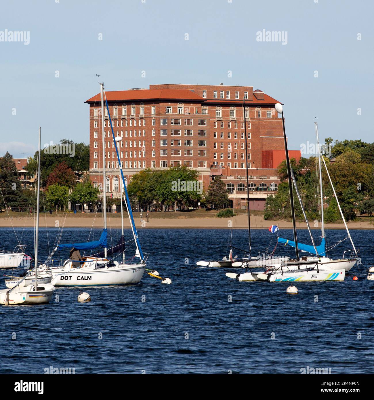 Die Marina des Minneapolis, Minnesota Sailing Center am Lake BDE Maka Ska mit den 1928 Beach Club Residences im Hintergrund. Stockfoto