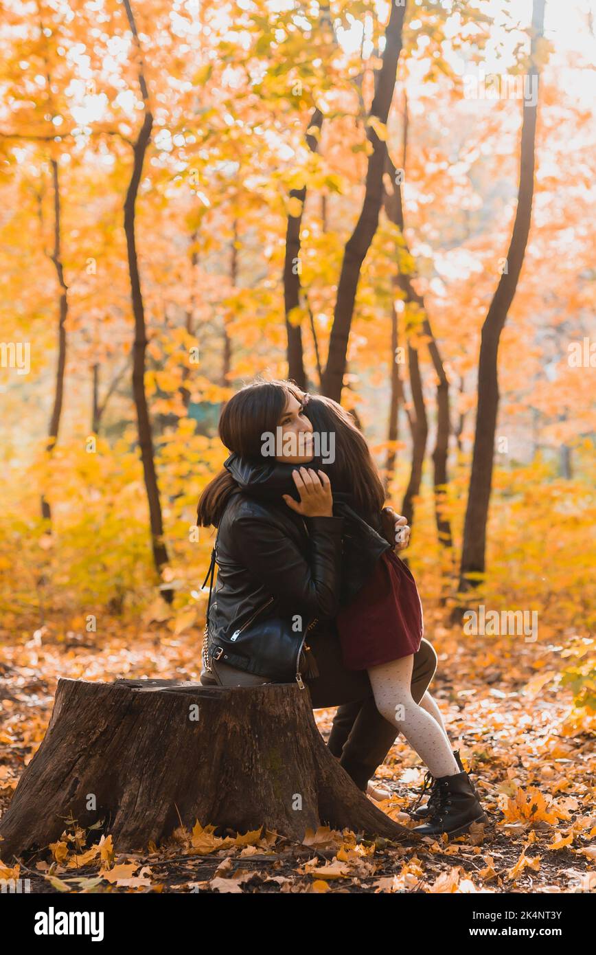 Mutter und Tochter verbringen Zeit zusammen im gelben Herbstpark. Saison- und Alleinerziehende Konzept. Stockfoto