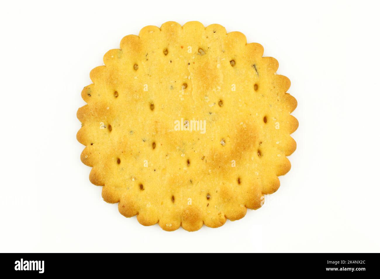 Ein salziger Cracker auf weißem Hintergrund isoliert. Runder Keks mit Löchern Stockfoto