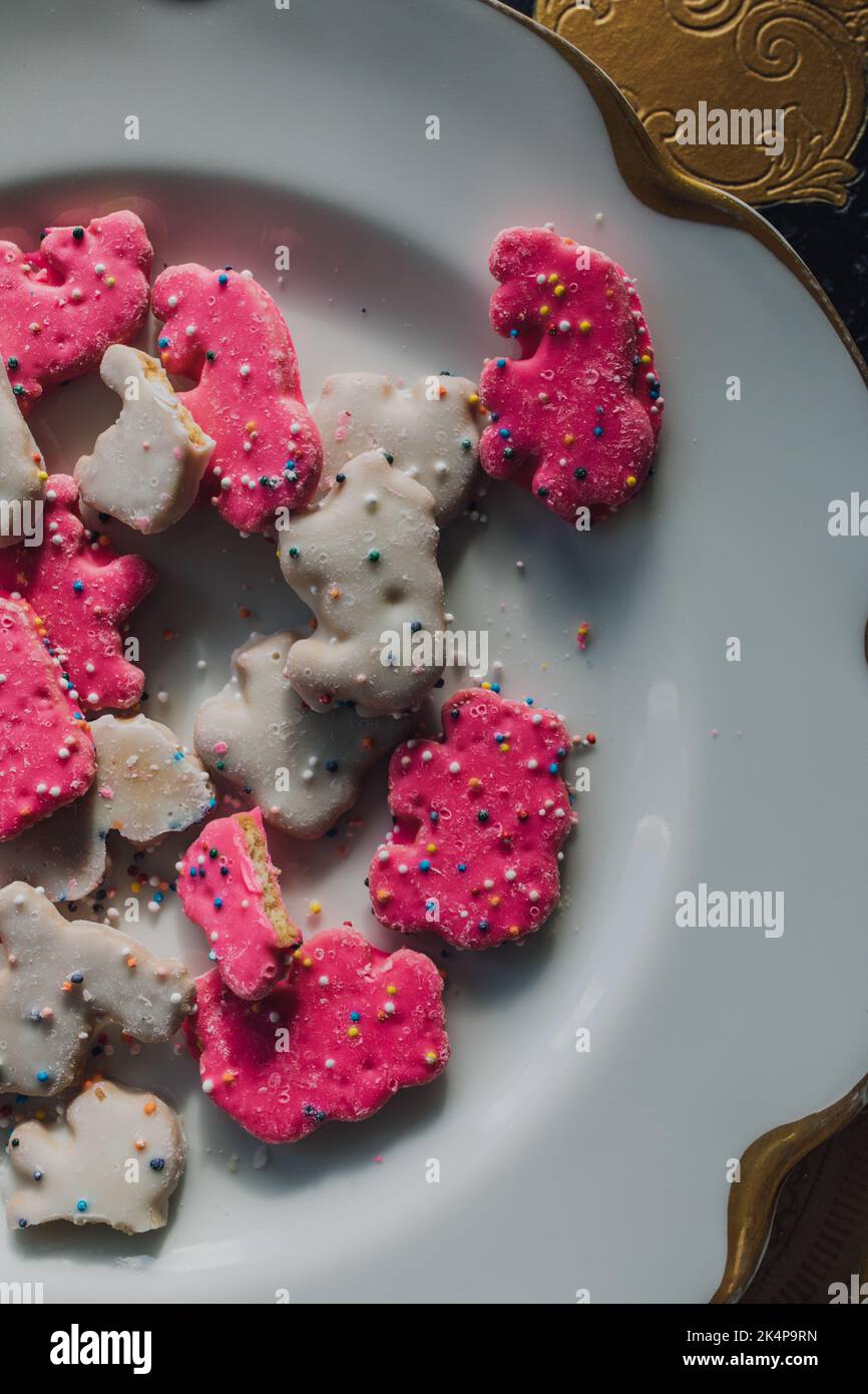 Frosted Circus Animal Cookie Pink und White bestreut Animal Cracker auf weißem Teller Stockfoto